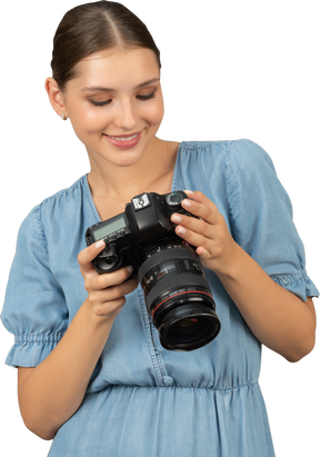 Front view of a smiling young woman in blue checking pictures