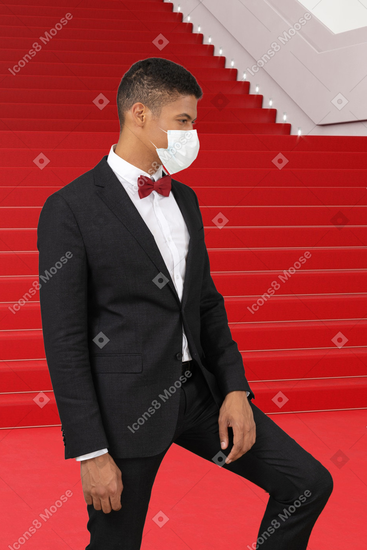 A man in a tuxedo and a face mask