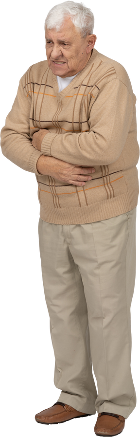 Vista frontal de um velho em roupas casuais, sofrendo de dor de estômago