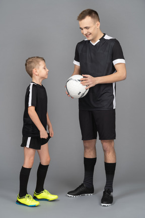 Full-length of a young man coaching little boy