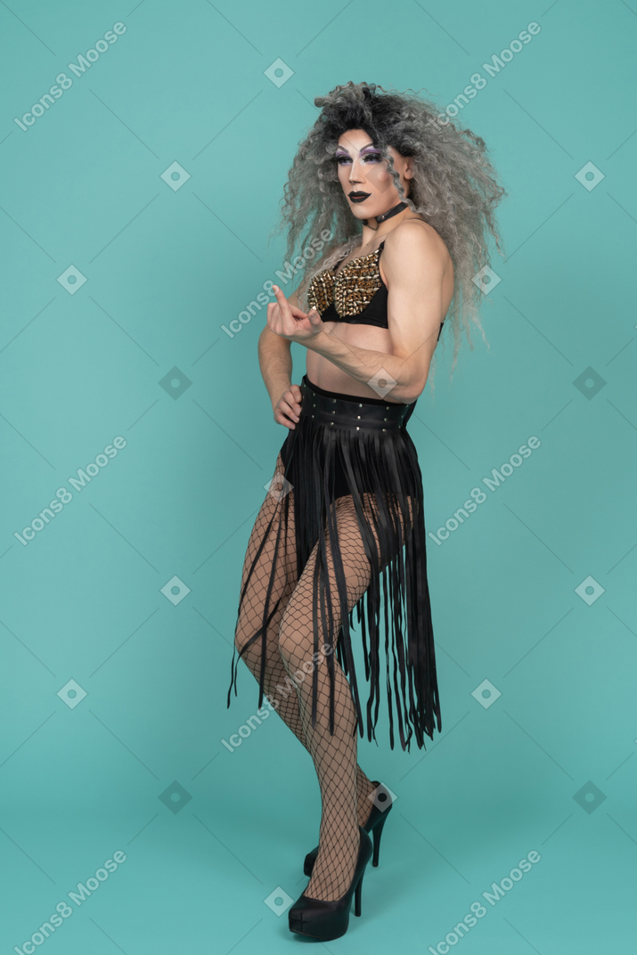 Drag queen in all black outfit beckoning with finger