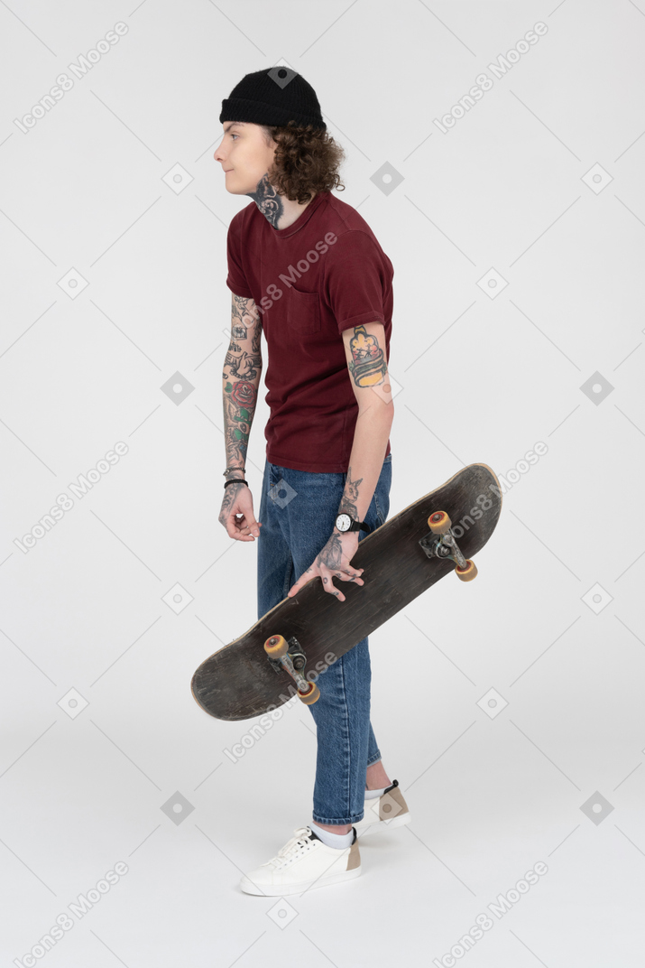 Un adolescent marchant avec sa planche à roulettes
