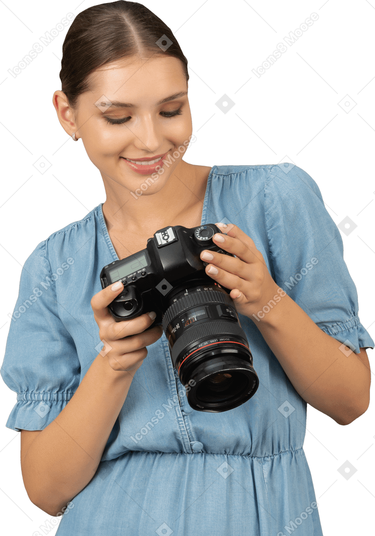 Vista frontale di una giovane donna sorridente in blu che controlla le immagini