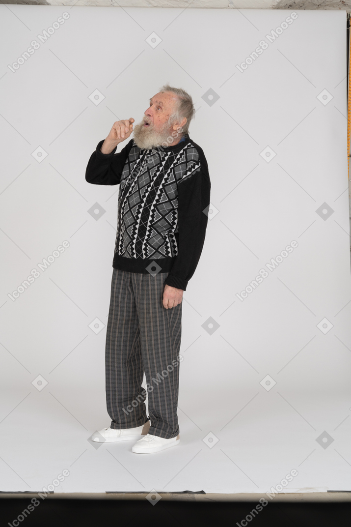 Old man looking up with hand at mouth