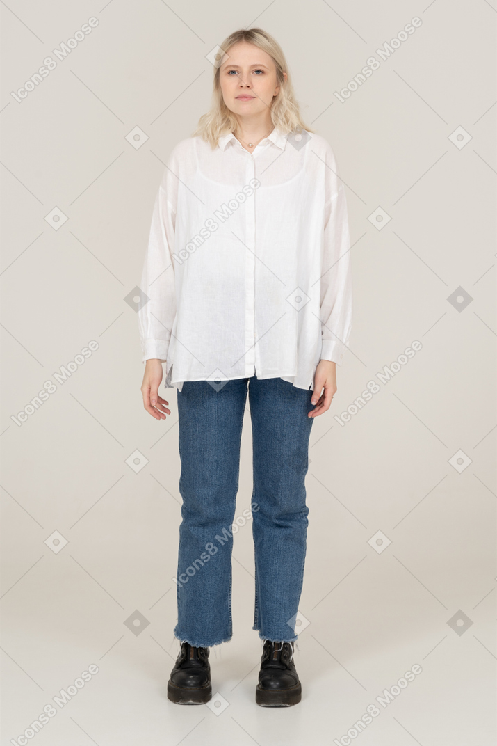 Front view of a cute blonde female in casual clothes looking aside