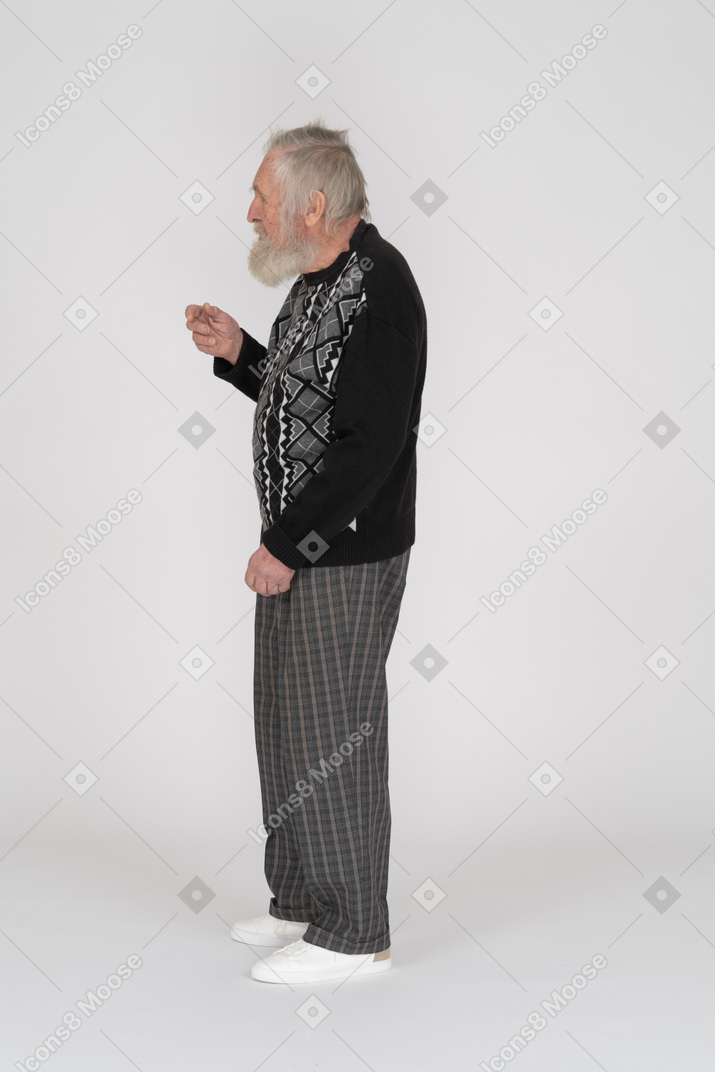 Side view of an elderly man raising his hand