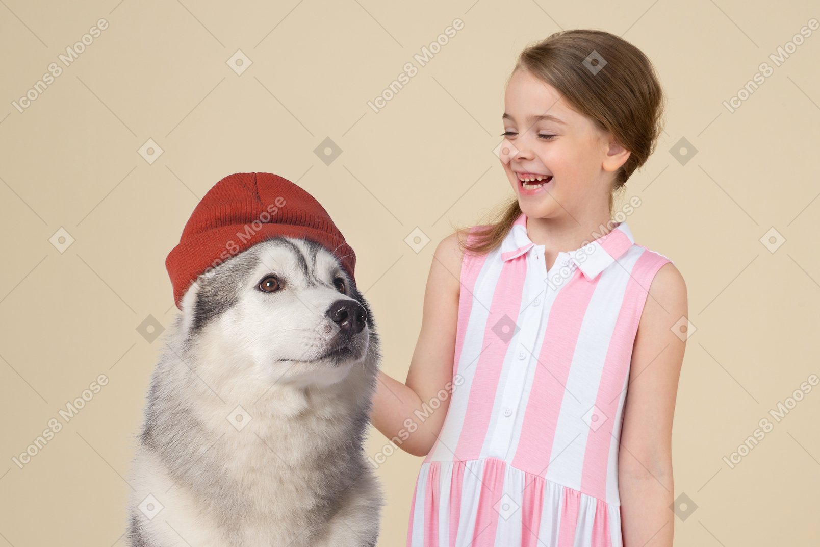Jolie petite fille et un chien husky coiffé d'un chapeau