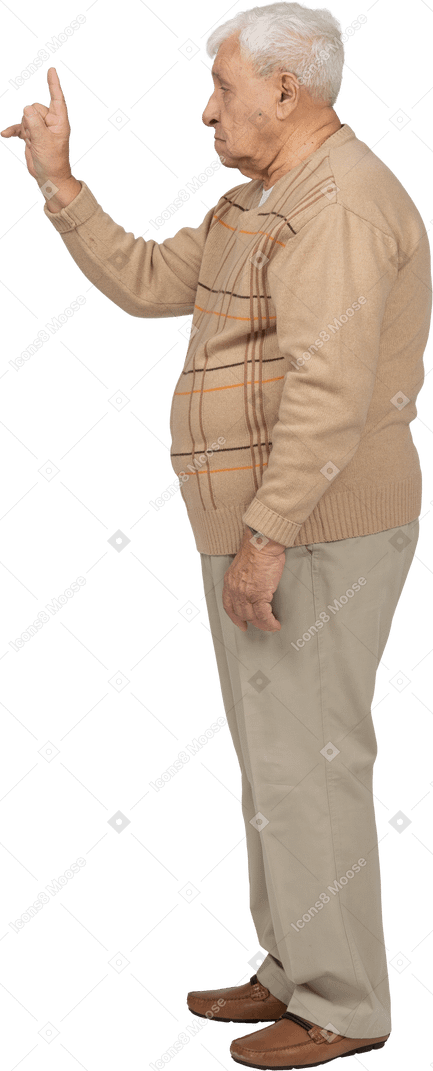 Side view of an old man in casual clothes pointing up with finger