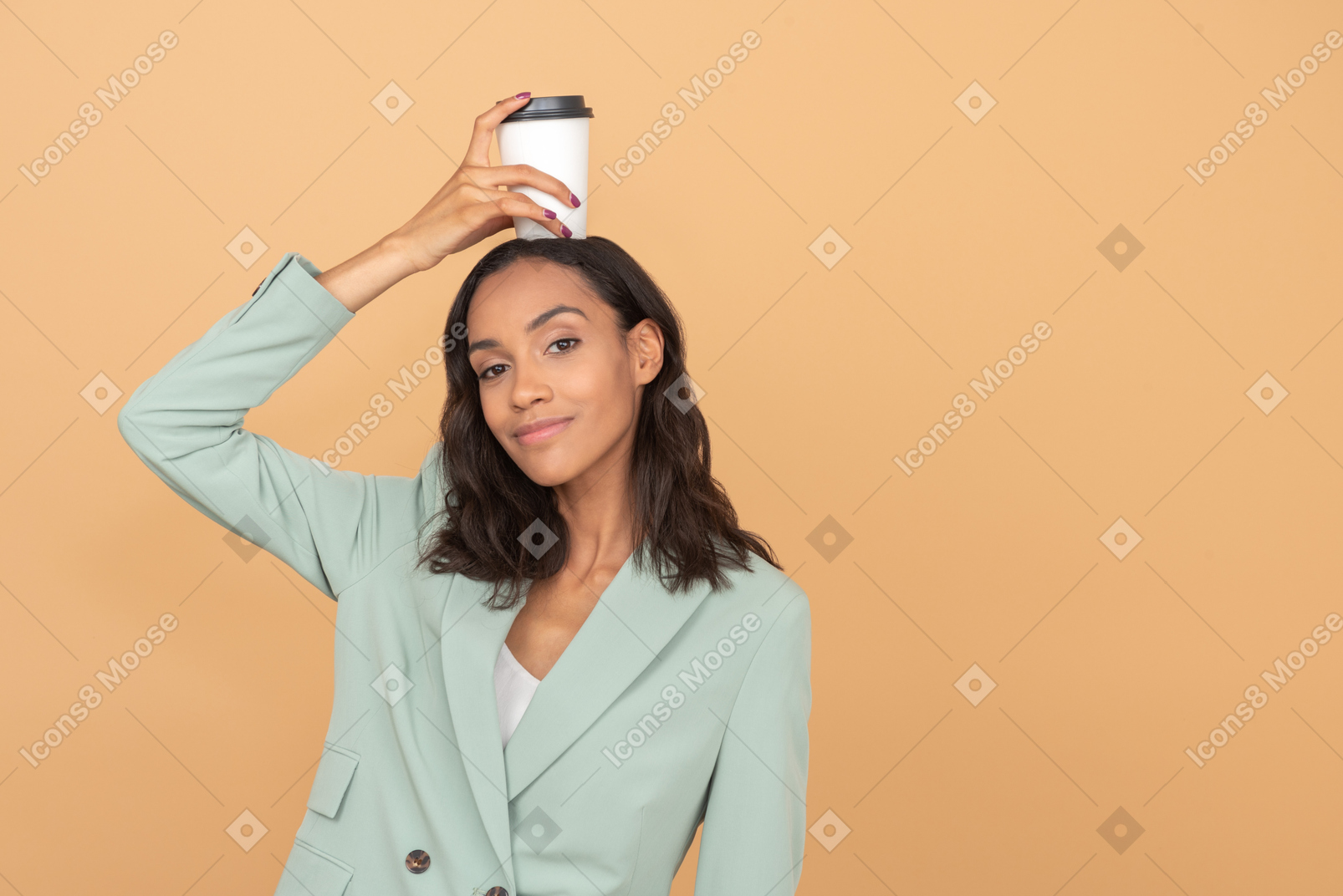 Mulher jovem e atraente segurando uma xícara de café na cabeça dela