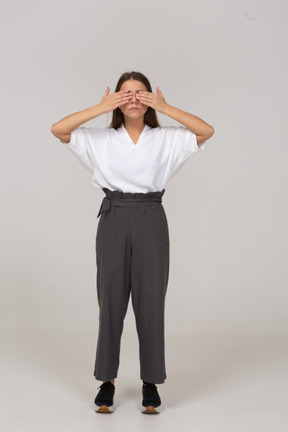 Vista frontal de uma jovem com roupa de escritório, fechando os olhos