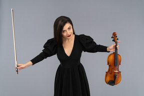 Front view of a female violin player in black dress making a bow