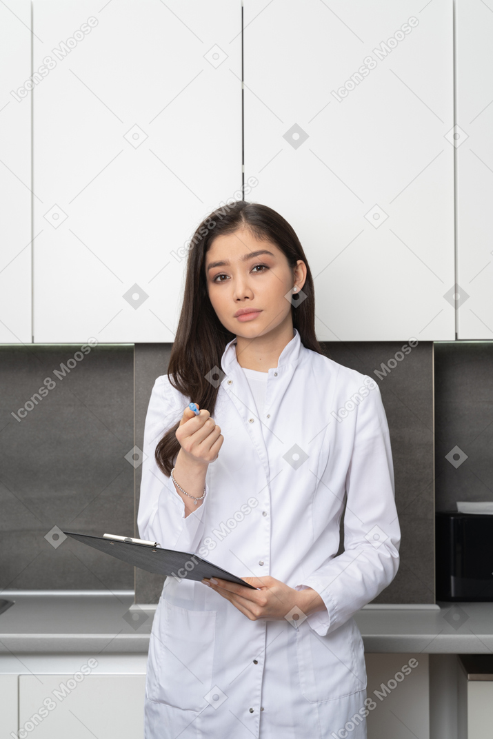 Vista frontal de una mujer joven mirando a la cámara y apuntando directamente con su bolígrafo