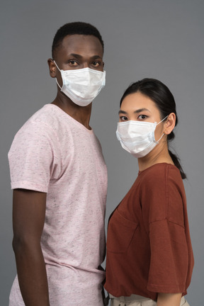 Una giovane coppia che indossa maschere per il viso