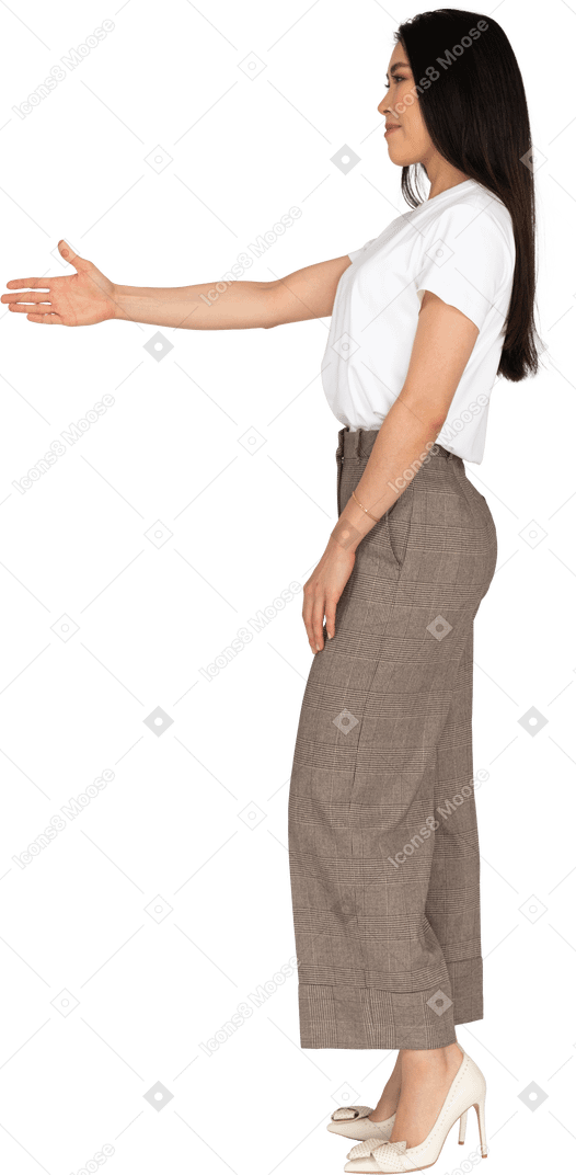 Side view of a greeting young lady in breeches and t-shirt outstretching her hand