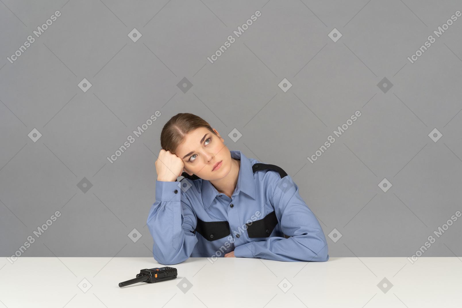 A bored female security guard leaning on her hand
