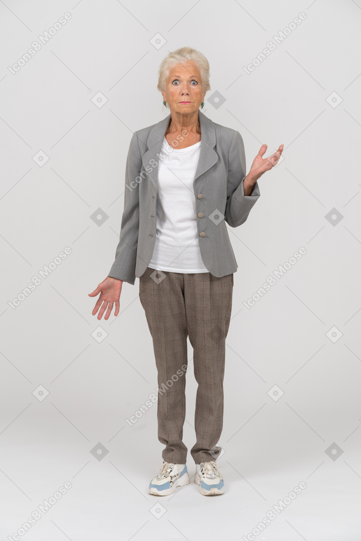 一个穿西装的老妇人的前视图看着相机和打手势