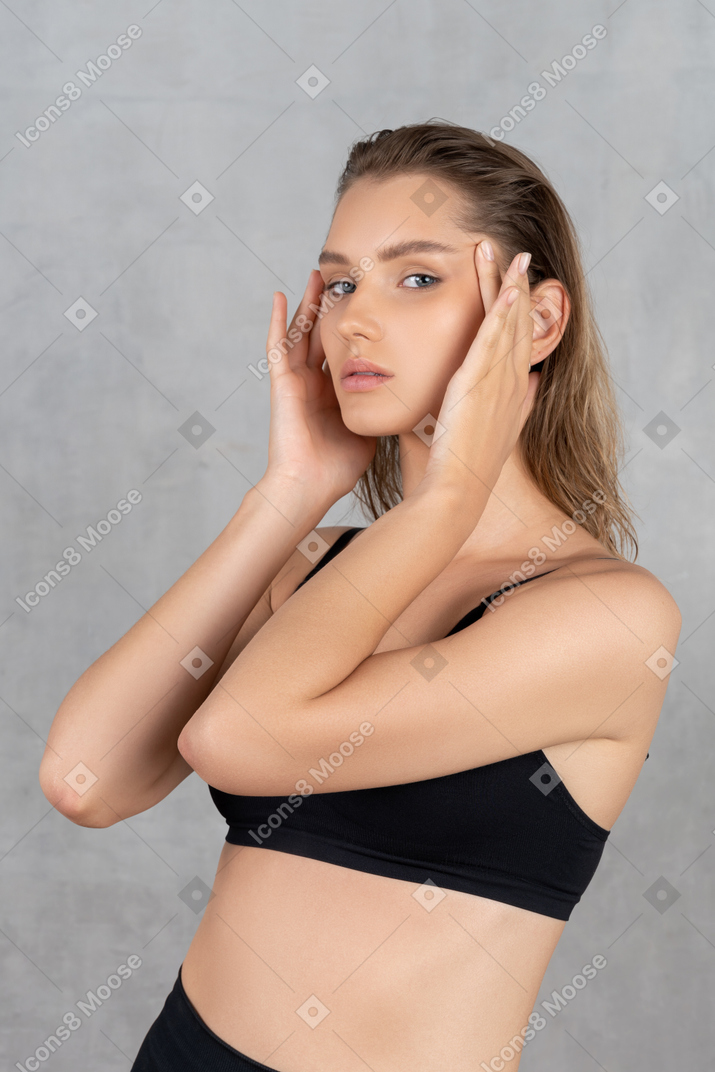 Portrait of attractive woman tightening her face with hands