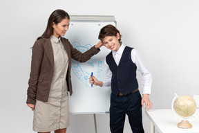 Angry young teacher pulling her pupil's ear