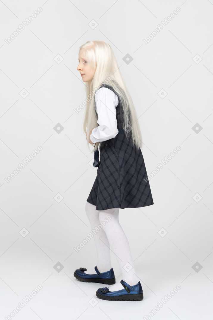 Side view of a schoolgirl anxiously looking around
