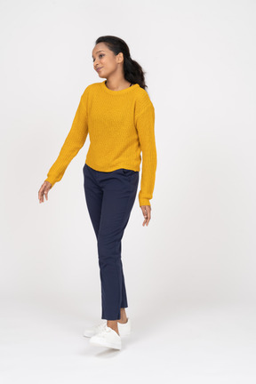 Front view of a happy girl in casual clothes standing with outstretched arms