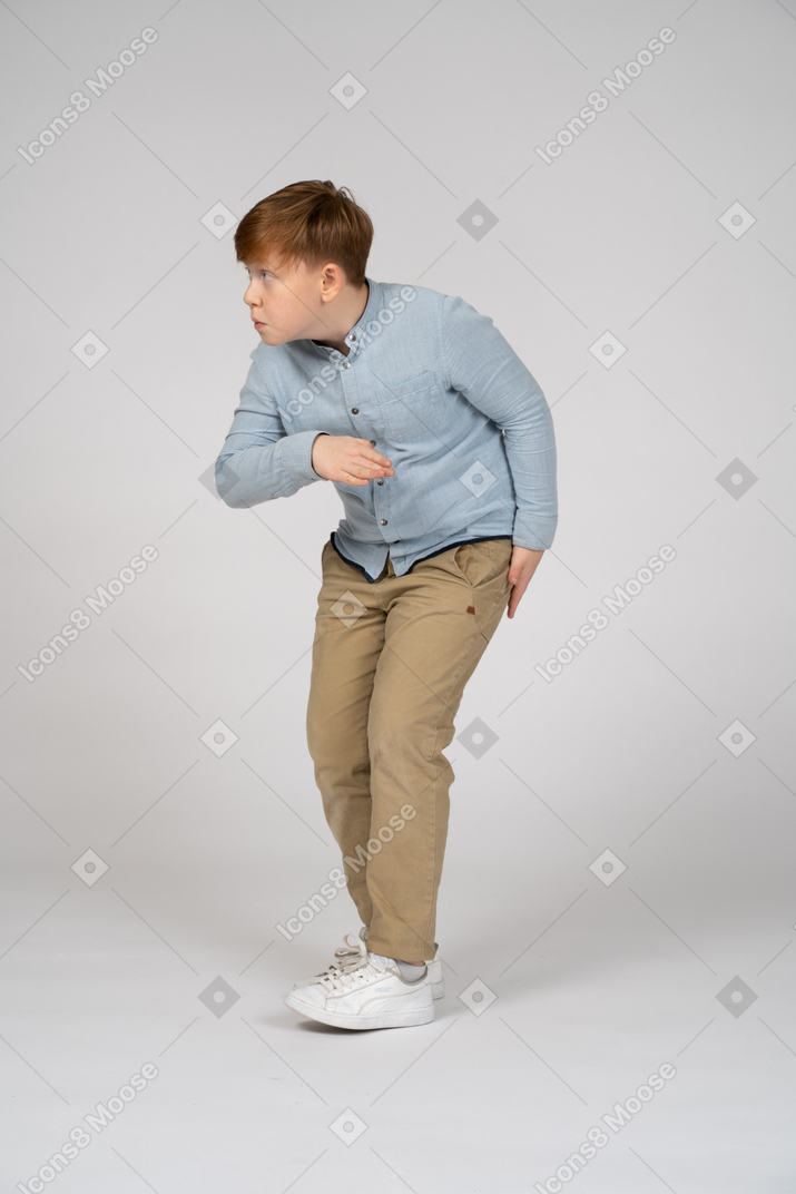 A boy in a blue shirt folding in on himself