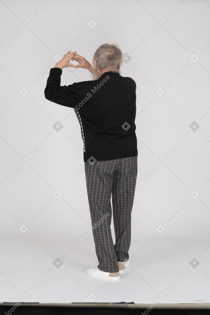 Rear view of old man showing heart gesture