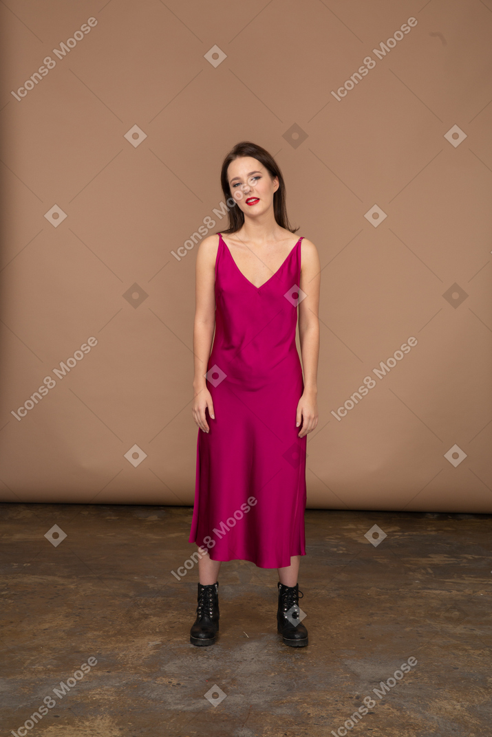 カメラを見て美しい赤いドレスを着た若い女性の正面図