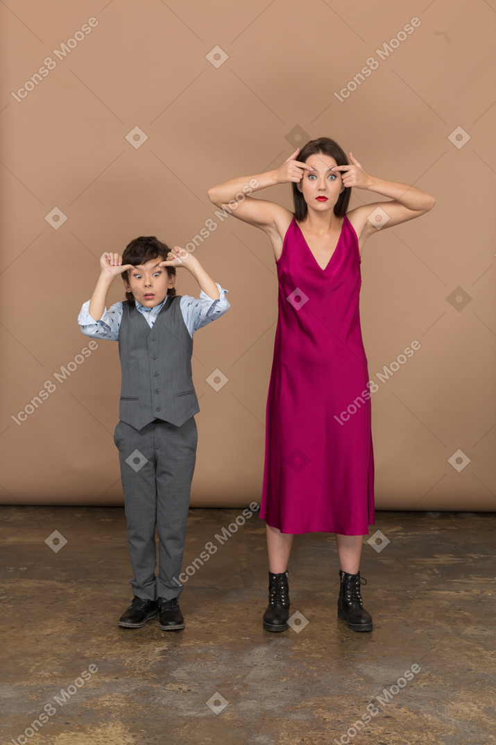 Boy and woman widening their eyes