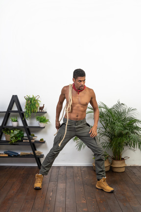 Muscular man standing with rope on his shoulder