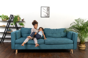 Good looking boy and girl play on the sofa