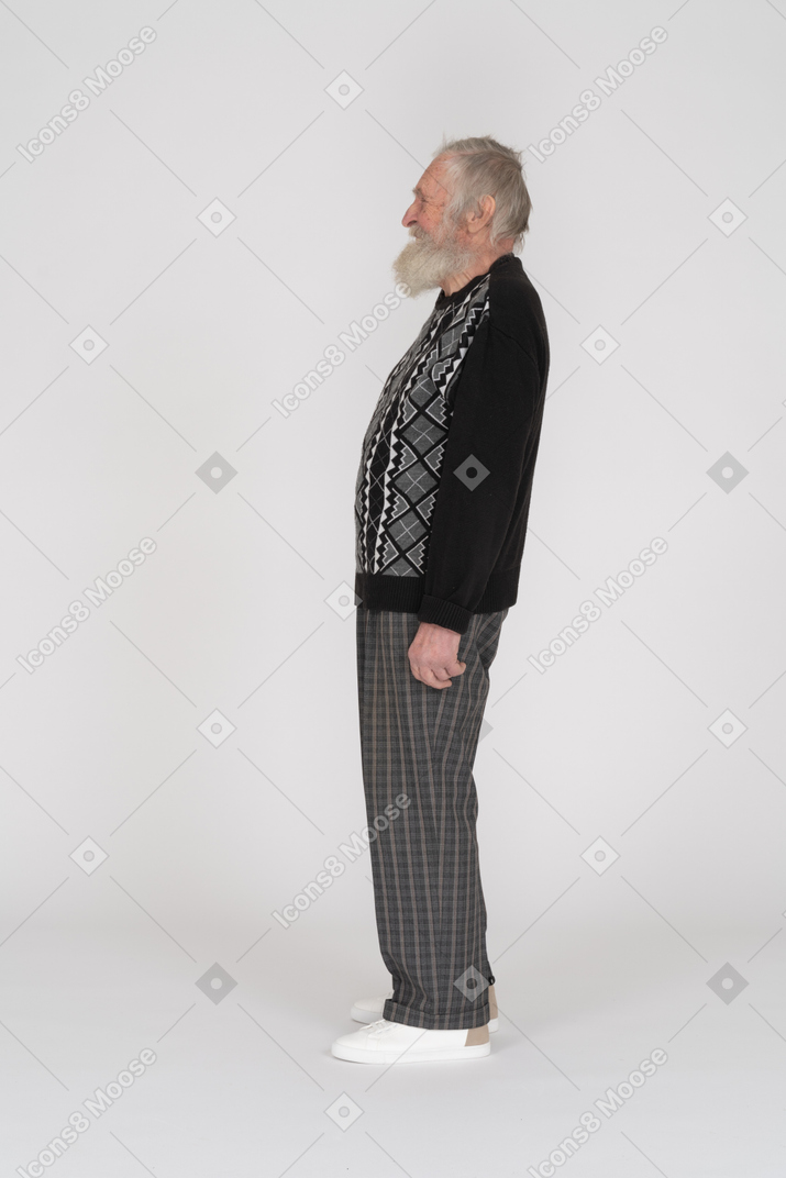 Vista laterale di un uomo anziano in piedi e sorridente