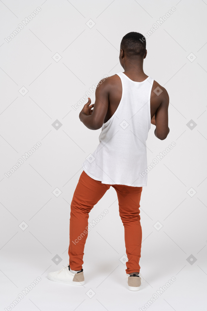 腕を曲げて立っている黒人男性の背面図