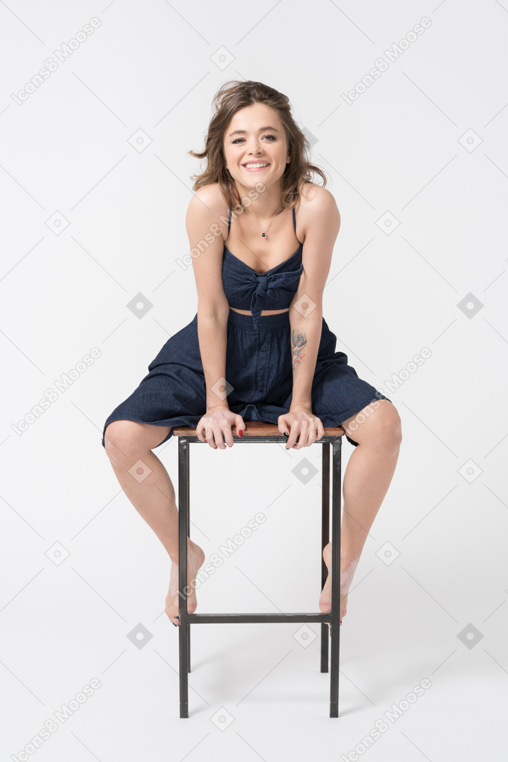 Smiling woman sitting with legs wide open