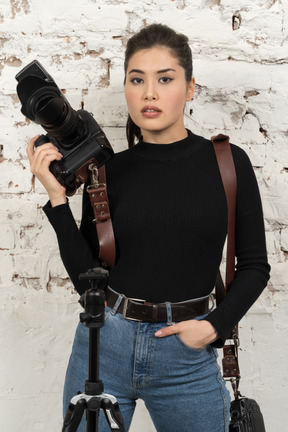 Hermosa mujer fotógrafa posando con equipo