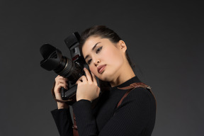 Bella giovane donna in posa con la macchina fotografica