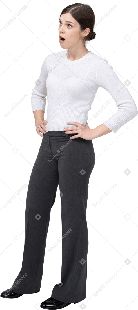 Front view of a young woman in casual clothes posing with hands on hips