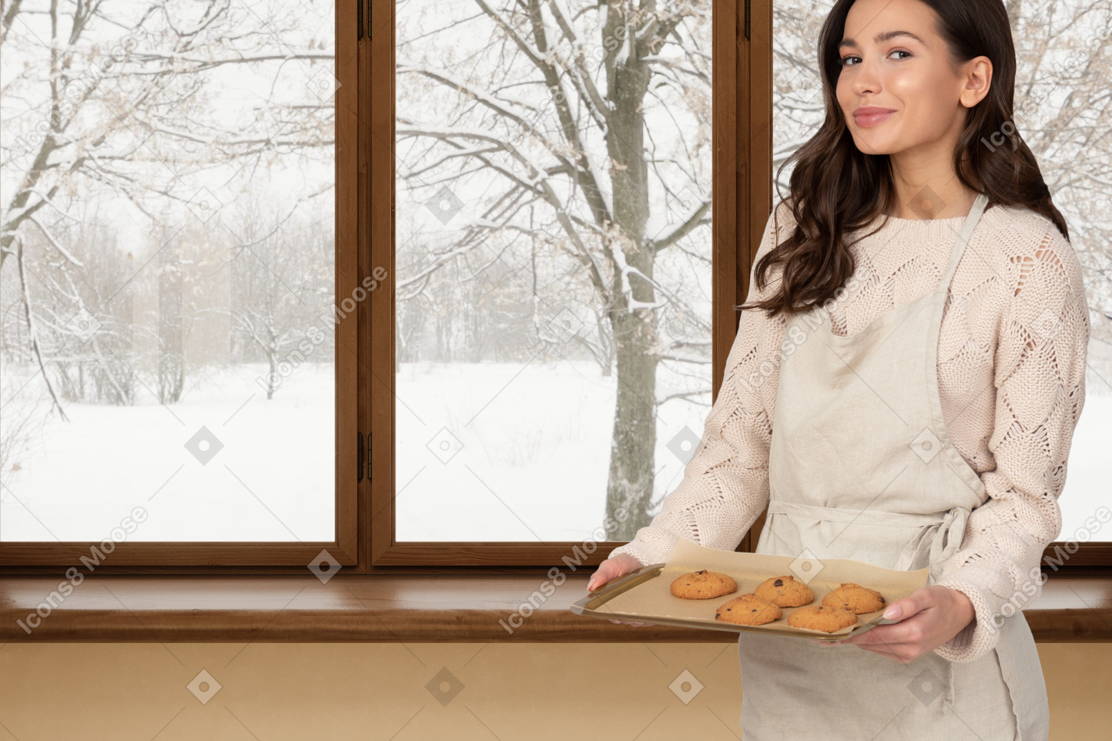 A woman holding a tray of cookies in front of a window