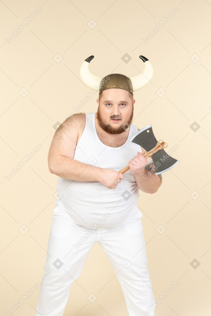 Um homem de tamanho grande em branco com um capacete com chifres na cabeça, segurando um machado de duas lâminas