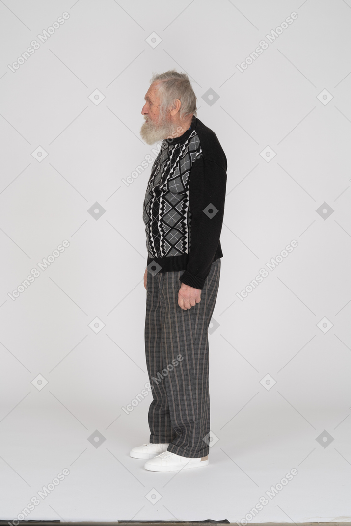 Vue latérale d'un vieil homme debout dans des vêtements sombres