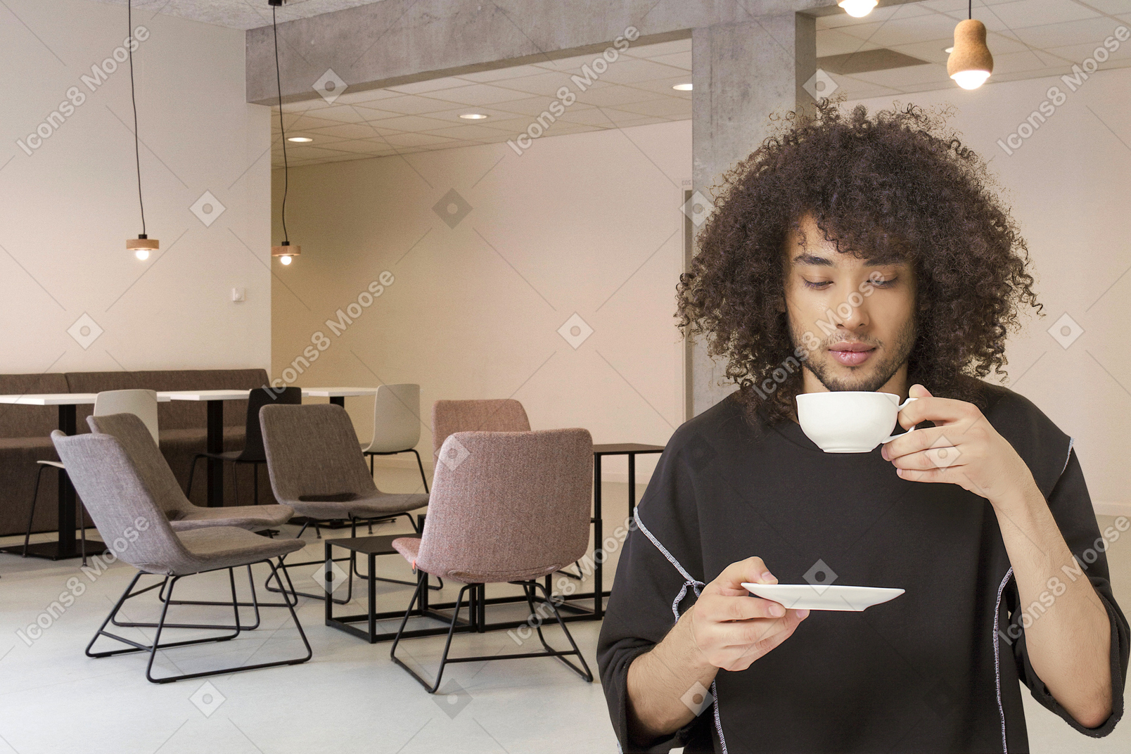 A man drinking a cup of coffee in a conference room