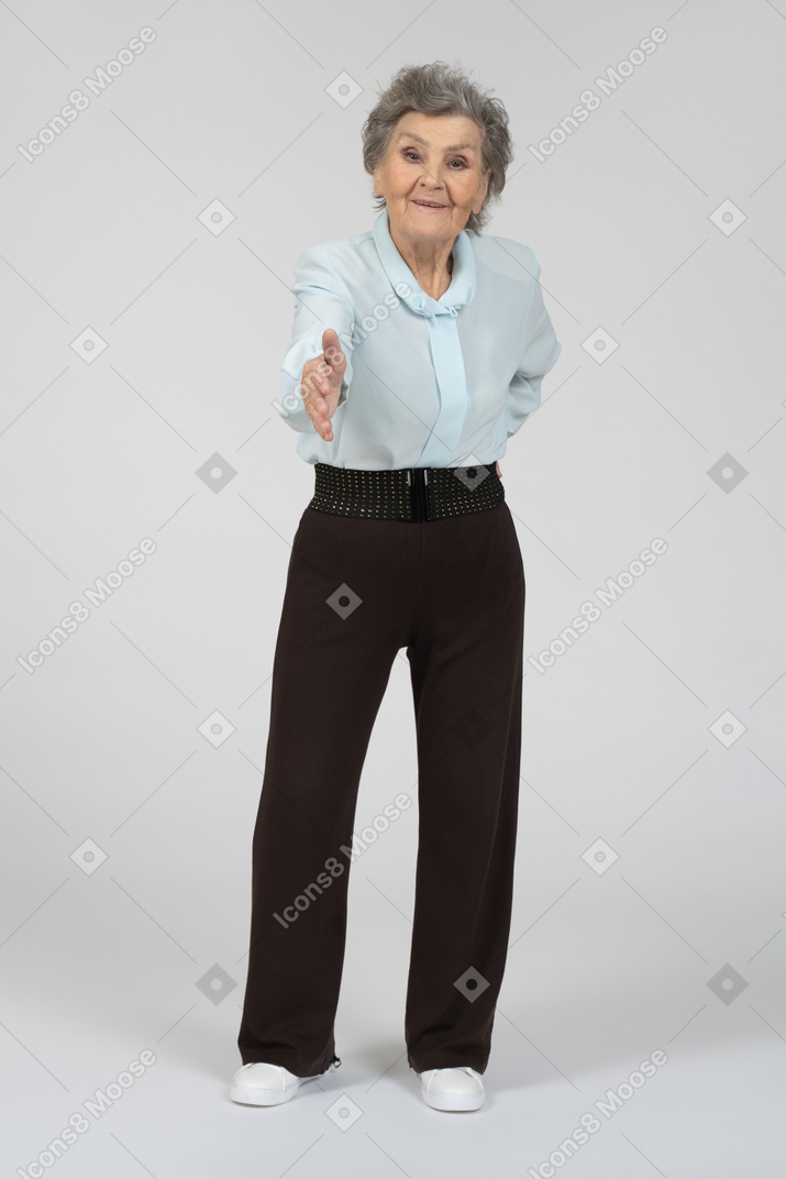La anciana extiende su mano y saluda