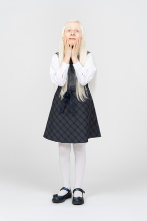 Schoolgirl holding her face and looking sad