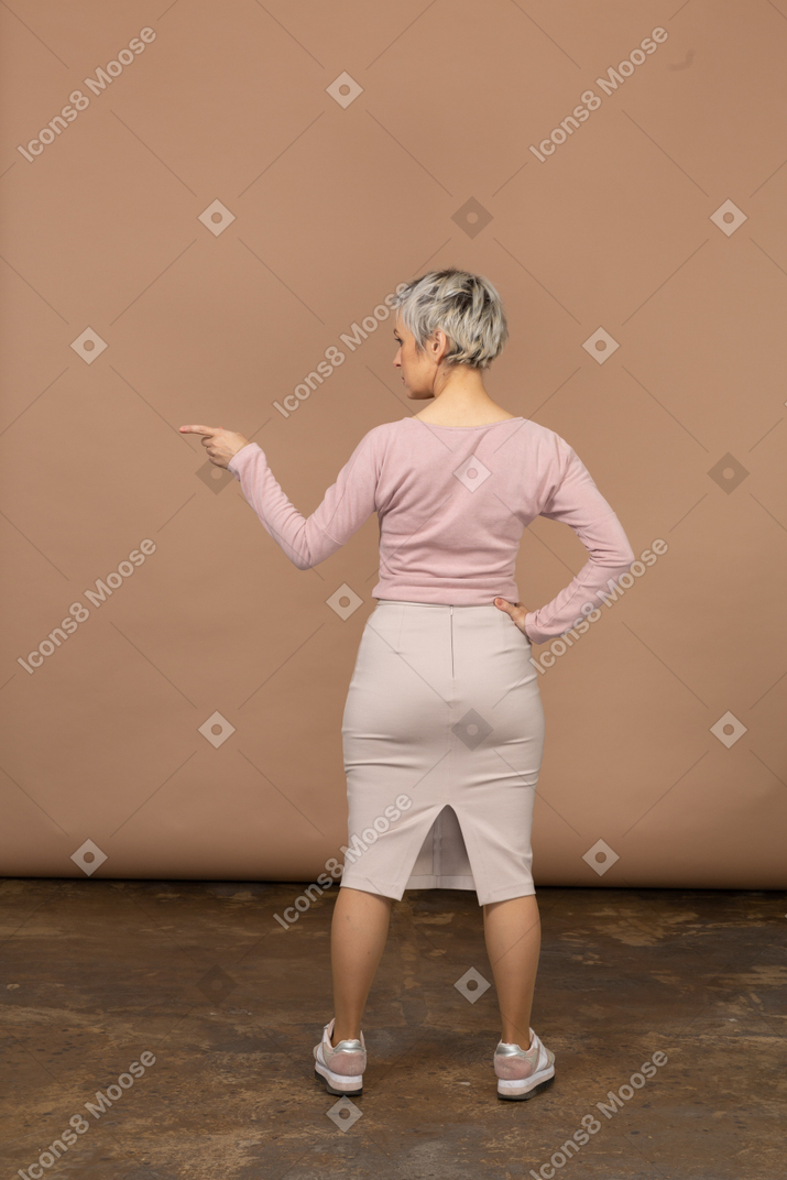 Retrovisor de uma mulher com roupas casuais apontando com o dedo