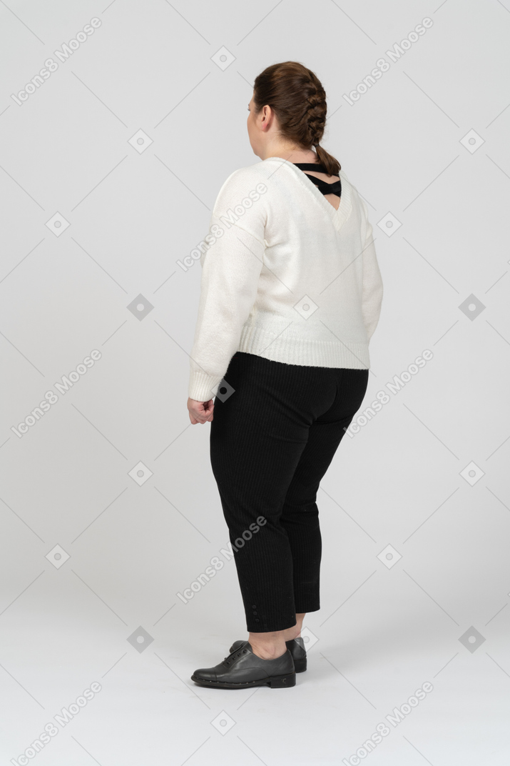 프로필에 서있는 흰색 스웨터에 플러스 크기 여자