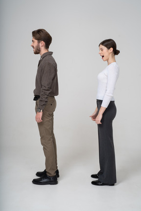 Side view of a yawning young couple in office clothing