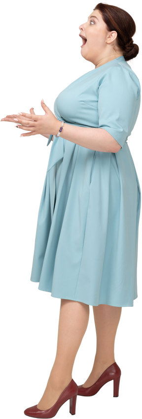 Vista laterale di una donna impressionata in abito blu