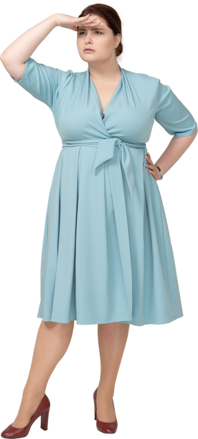 誰かを探している青いドレスを着た女性の正面図