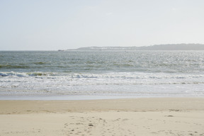 Sandy beach, sea and hills in the distance