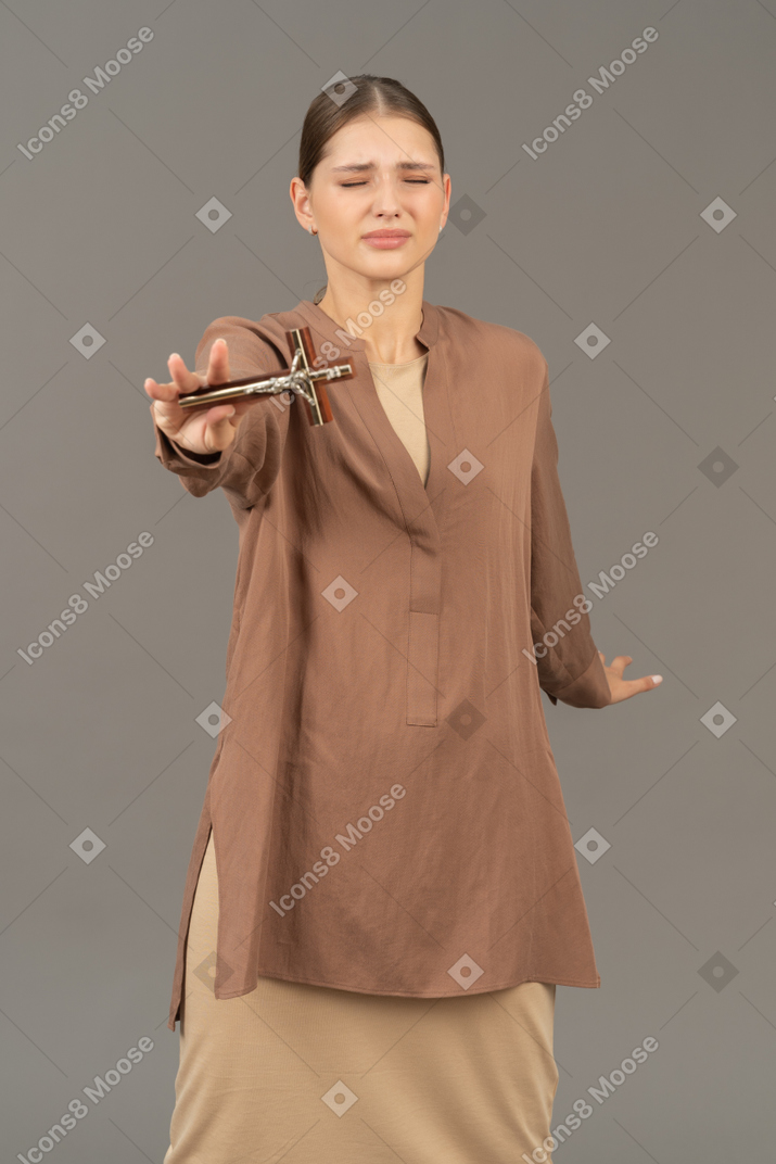 Wincing lady showing off a cross