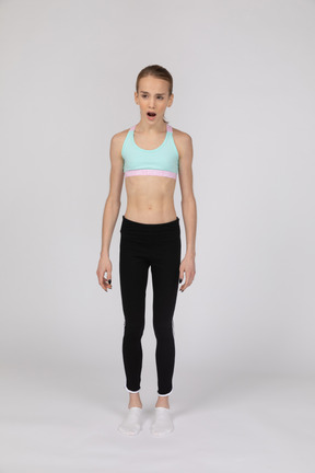 Teen girl in sportswear standing with her mouth open